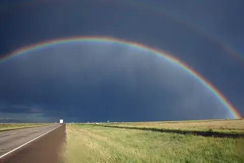 A double rainbow over an empty stretch of highway