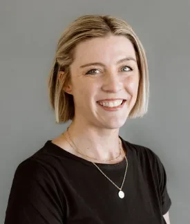 Laura Donelan wearing a black t-shirt in front of a gray background.