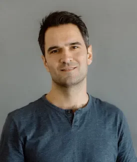 Matt Oliveira wearing a green t-shirt in front of a gray background.