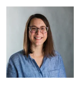Kris Konrady wearing glasses and wearing a blue button down shirt.