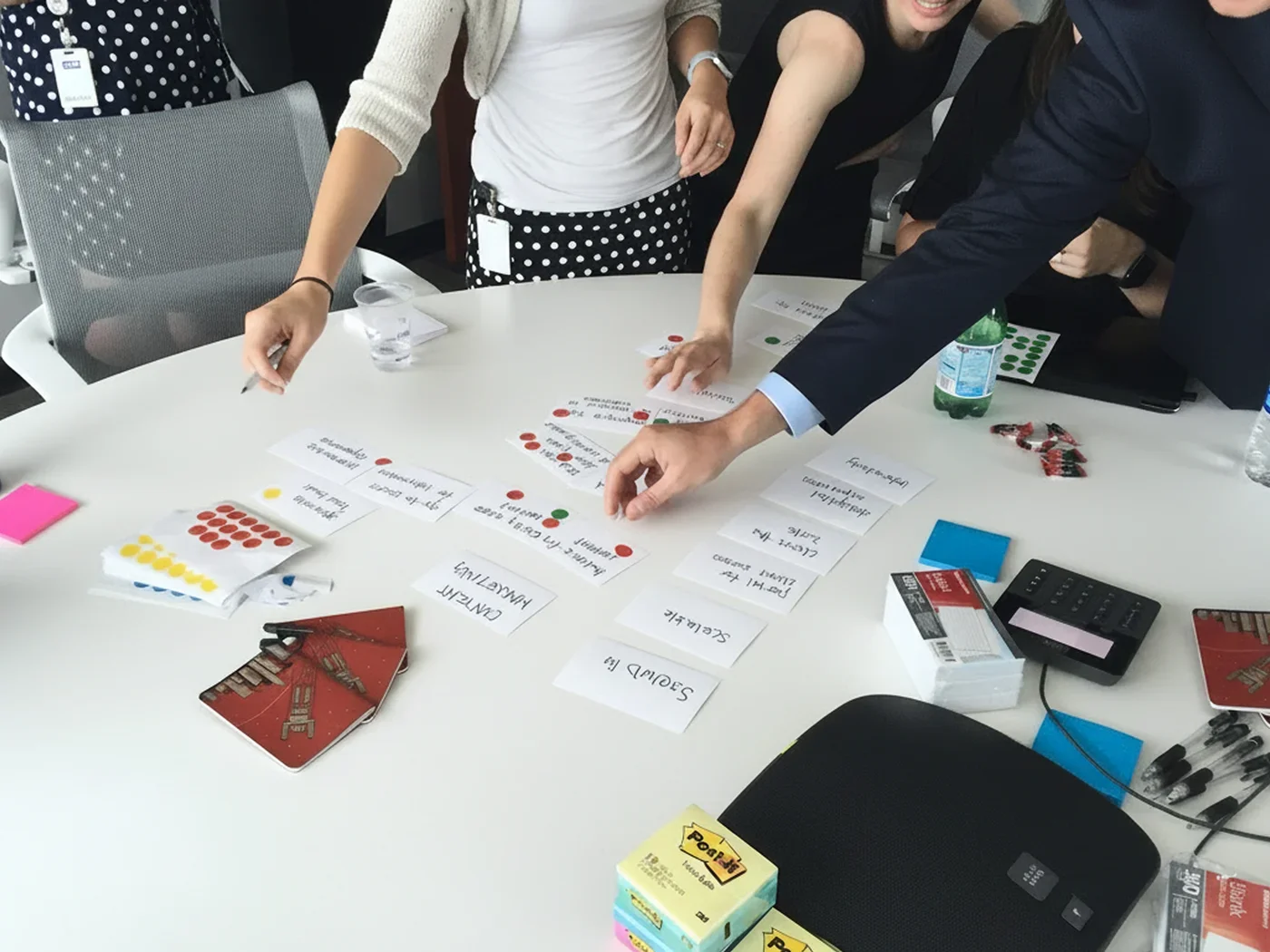 A group of people doing sticky dot voting during a collaborative workshopping exercise