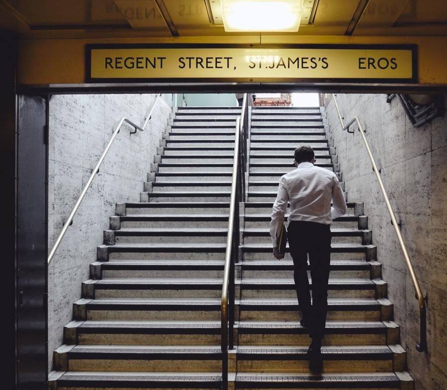 person walking up some stairs to the street above