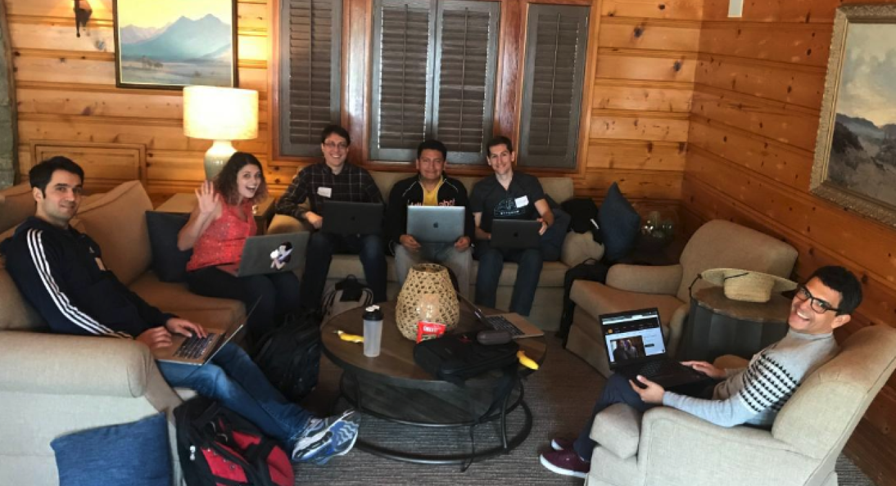 Group of Lullabot team members sitting on sofas and chairs working together on their laptops.