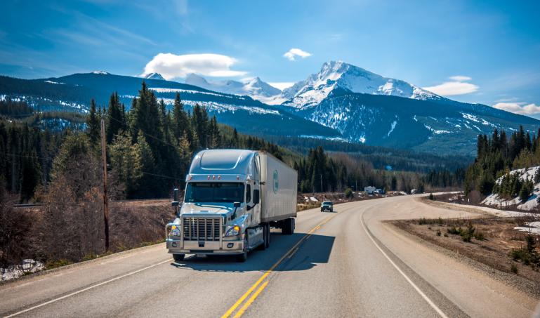 Large truck hauling heavy load over mountains