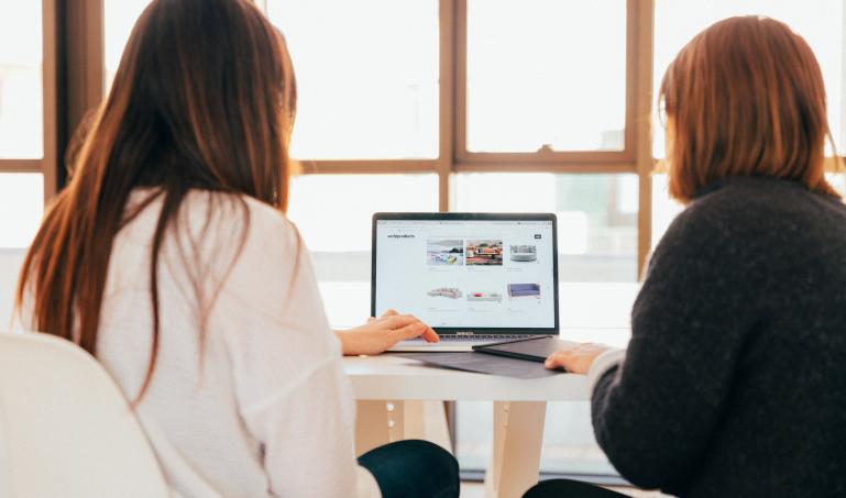 Two people looking at a laptop