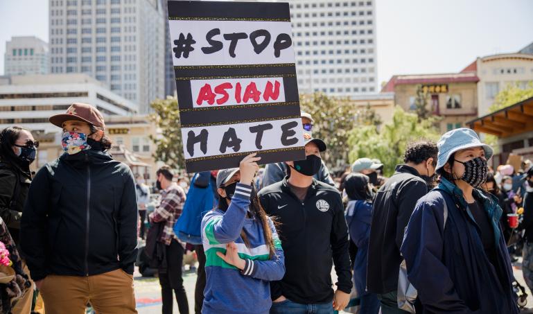 People holding signs at a protest against Asian hate
