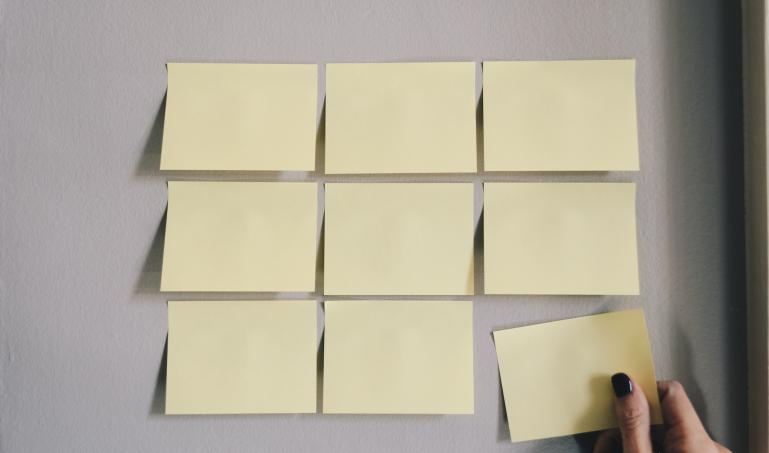 Post it notes arranged in a square on the wall.