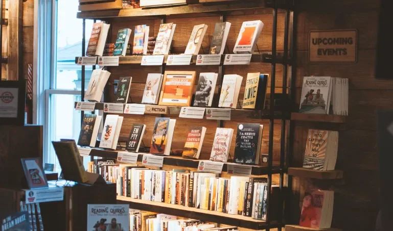 Shelves in a bookstore, with sunlight coming through the front door
