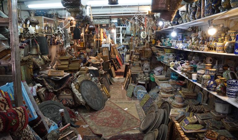 Shelves full of odds and ends like plates and jars, unorganized.