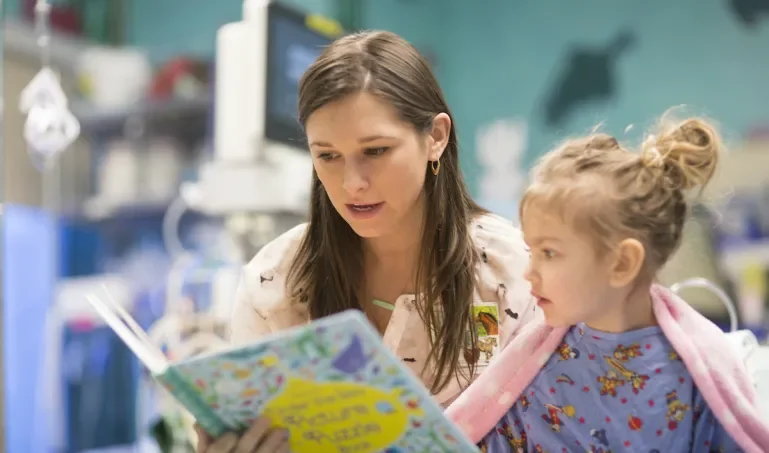 A woman reading a picture book to a child