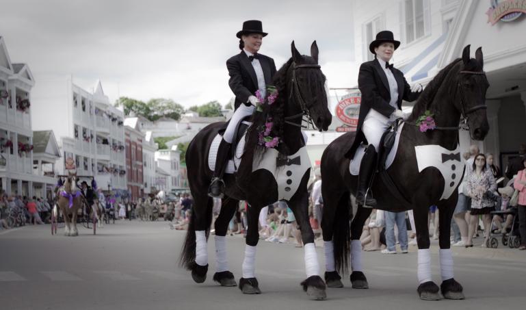 Finely dressed horses with riders in tuxedoes at the Mackinac Island Lilac Festival Parade, Sunday June 20, 2010