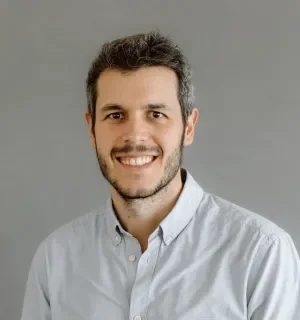 Ignacio Sanchez Holgueras wearing a white button down shirt in front of a gray background.