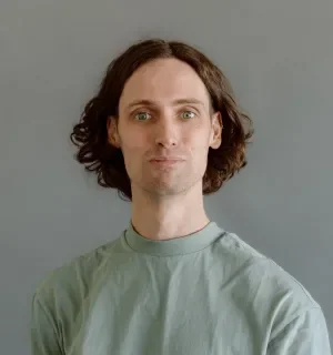 James Bain wearing a light green t-shirt in front of a gray background.