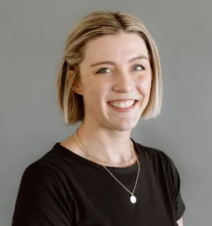 Laura Donelan wearing a black t-shirt in front of a gray background.