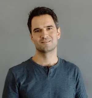 Matt Oliveira wearing a green t-shirt in front of a gray background.