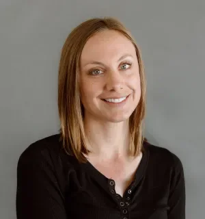 Morgan Eck wearing a long-sleeved black t-shirt in front of a gray background.