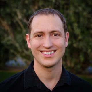 Nate Lampton standing in front of greenery.